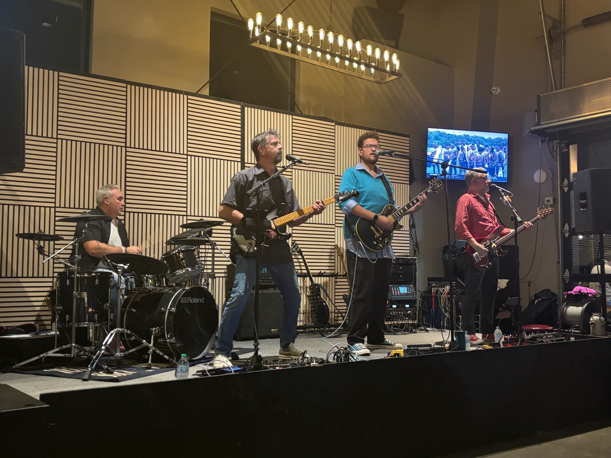 The Chucks performing together on a wood-paneled indoor stage