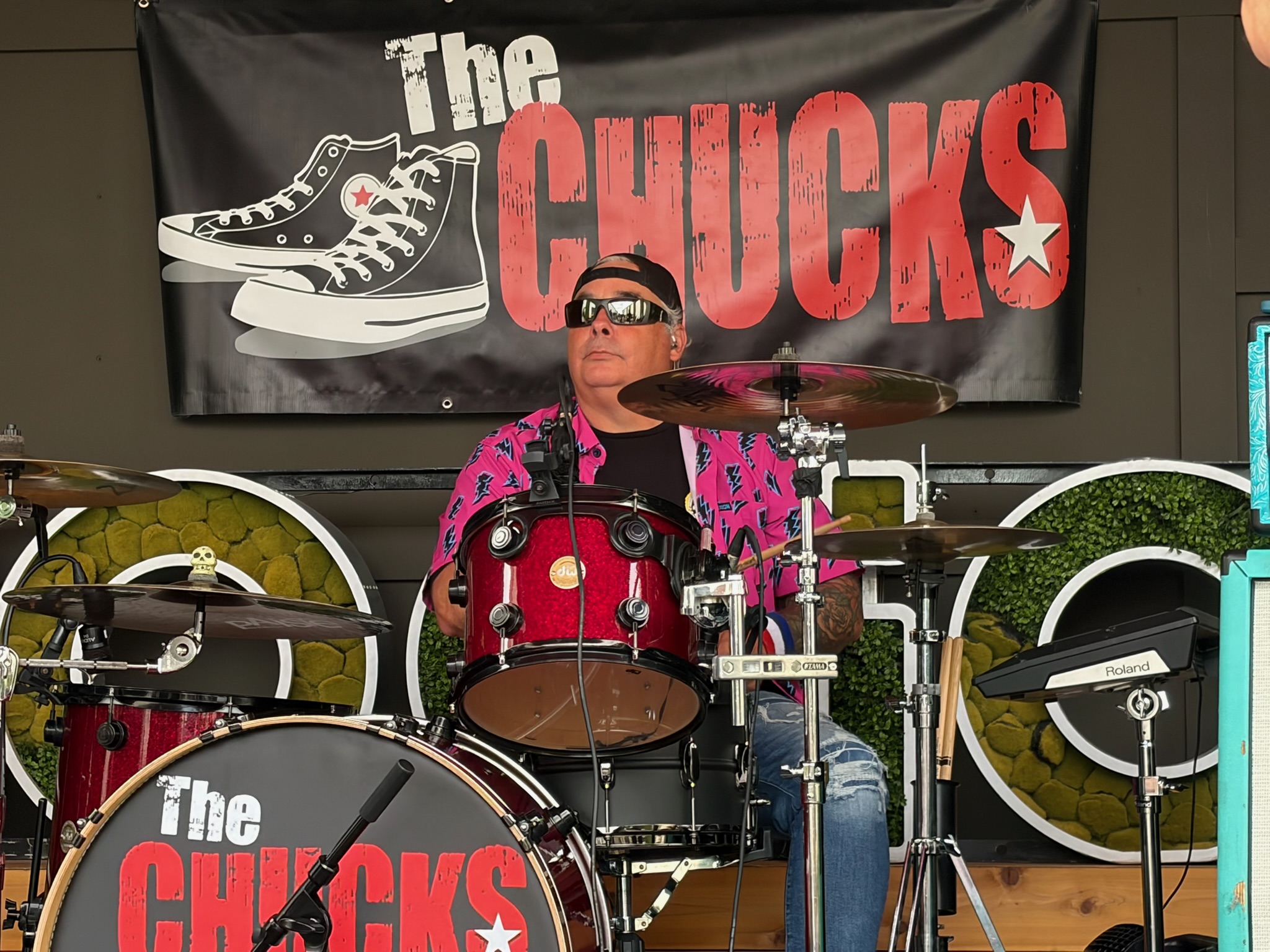 Tony playing drums beneath The Chucks logo