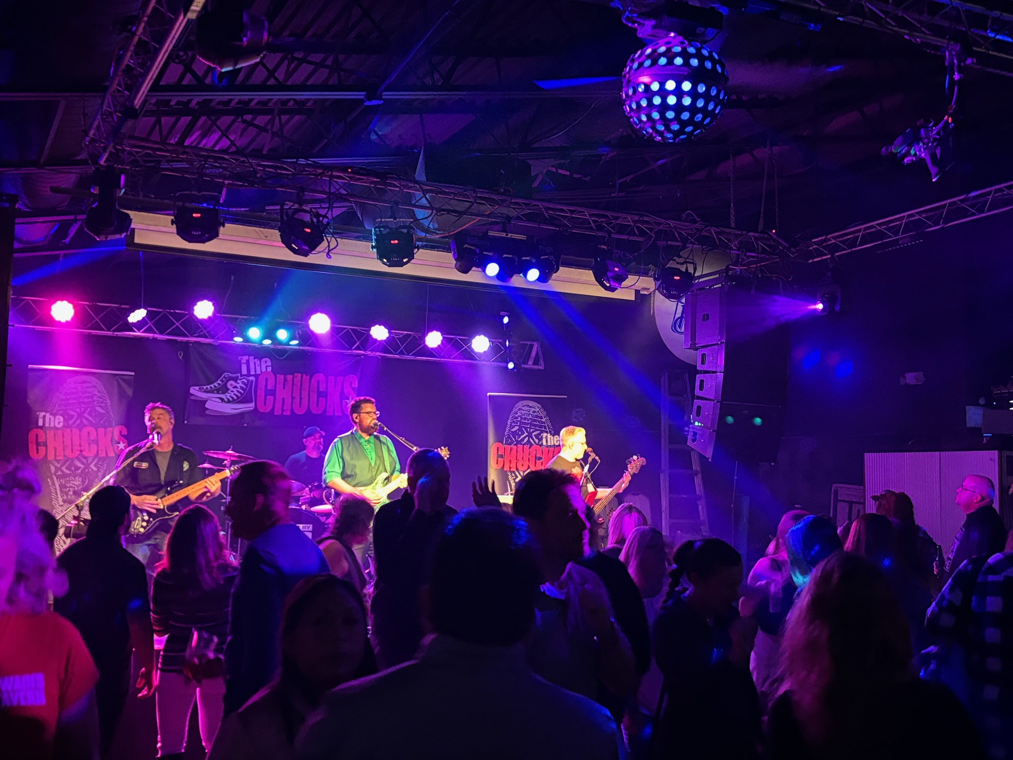 The Chucks driving a packed dance floor beneath pink and blue stage lights
