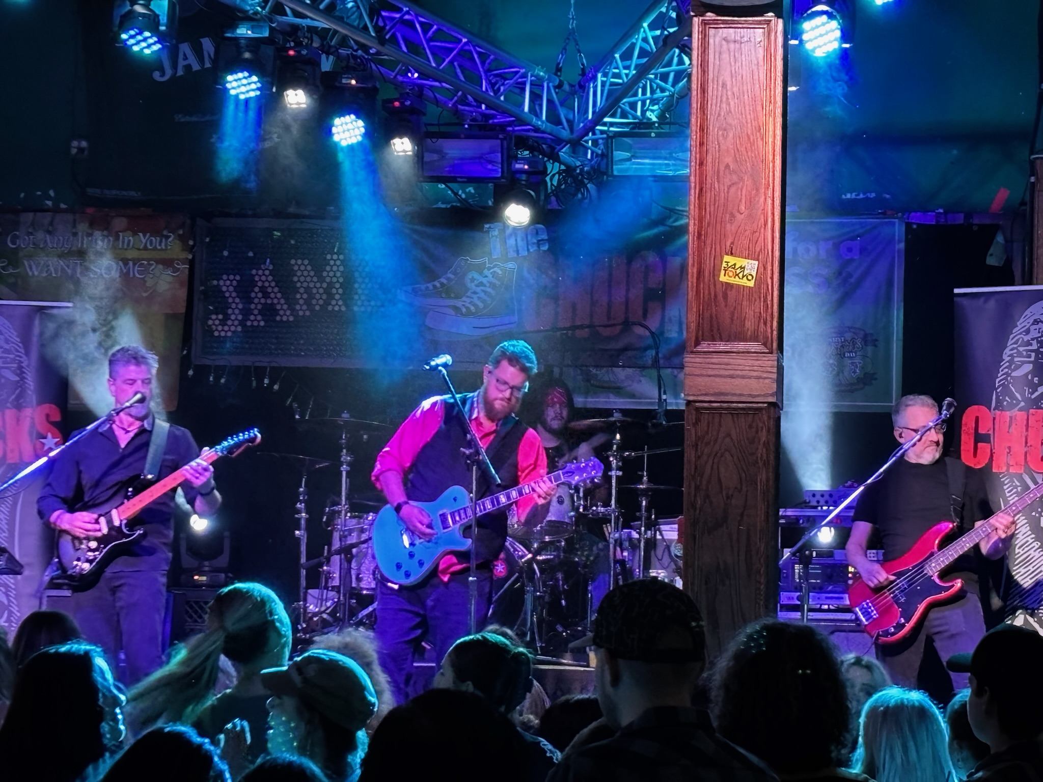 The Chucks playing to a lively crowd beneath blue stage lights