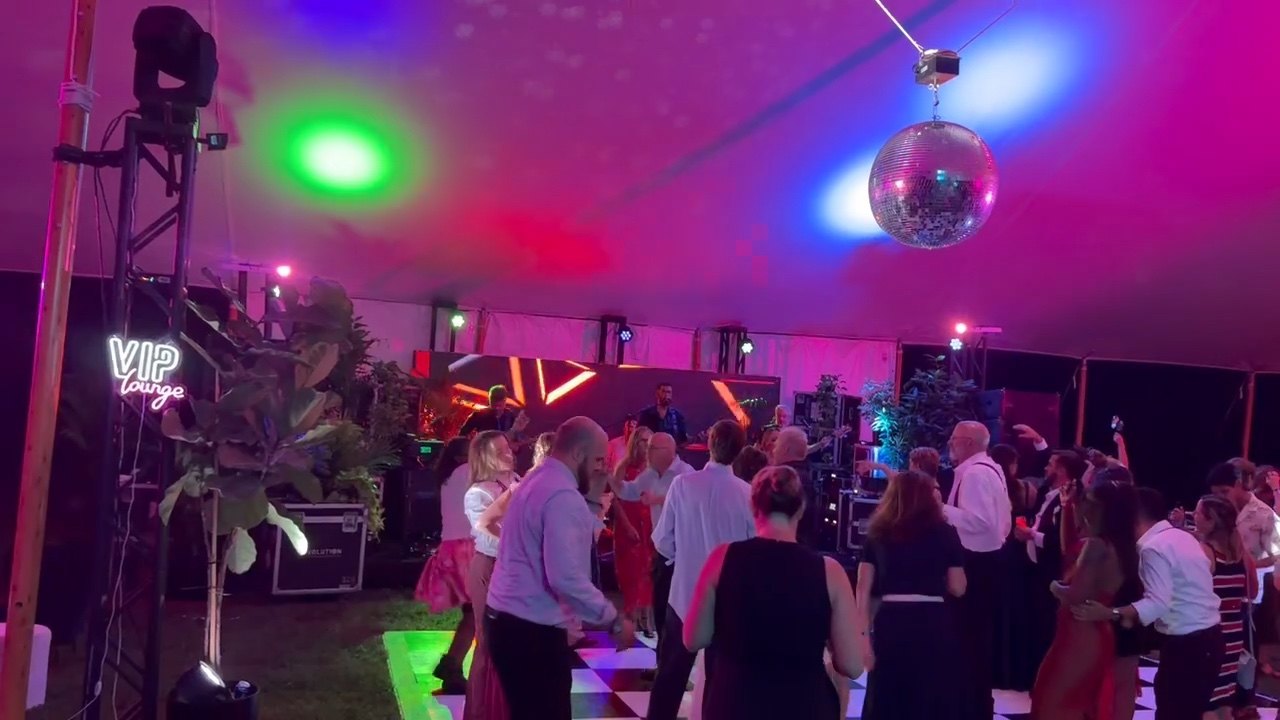 Wedding guests filling the dance floor with The Chucks playing beneath a disco ball