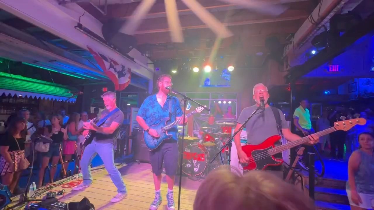 Neel, Joe, Bill, and Tony performing in the middle of a packed nightclub